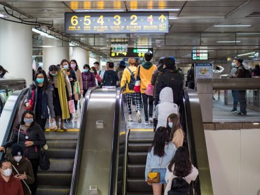 Taipei, Tayvan 'da toplu taşıma sisteminde yüz maskesi takan yolcular.