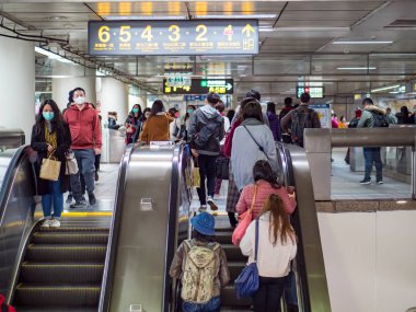 Taipei, Tayvan 'da toplu taşıma sisteminde yüz maskesi takan yolcular.