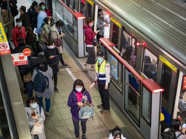 Taipei, Tayvan 'da toplu taşıma sisteminde yüz maskesi takan yolcular.