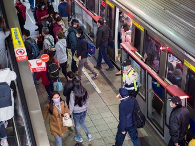 Taipei, Tayvan 'da toplu taşıma sisteminde yüz maskesi takan yolcular.