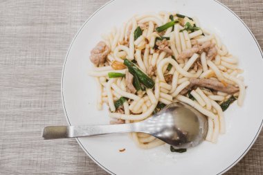 Domuz eti ve yeşil soğanlı kızarmış erişte.