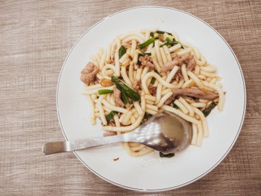 Domuz eti ve yeşil soğanlı kızarmış erişte.