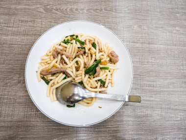 Domuz eti ve yeşil soğanlı kızarmış erişte.