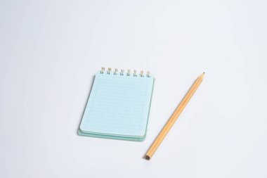 Beyaz masa arkaplanında tahta kalemle açık spiral boş defterin üst görünümü