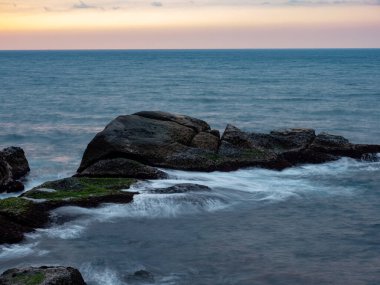 Güzel ipeksi su dalgaları ve deniz kıyısındaki kayalar