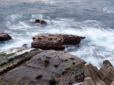 Güzel ipeksi su dalgaları ve deniz kıyısındaki kayalar
