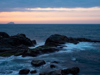 Güzel ipeksi su dalgaları ve deniz kıyısındaki kayalar