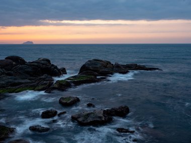 Güzel ipeksi su dalgaları ve deniz kıyısındaki kayalar
