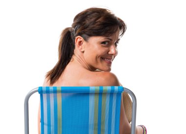 Bir sandalyede oturan mavi bikinili kadın