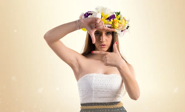 Жінка з короною квітів, фокусуючись пальцями — стокове фото