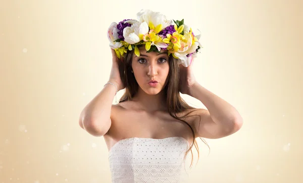 Menina com coroa de flores cobrindo seus ouvidos — Fotografia de Stock