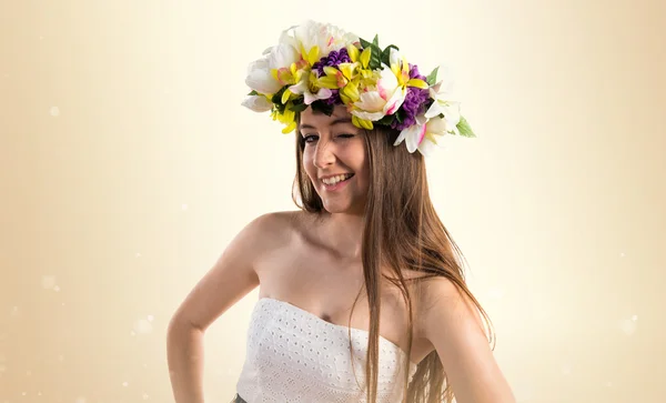 Menina com coroa de flores piscando — Fotografia de Stock