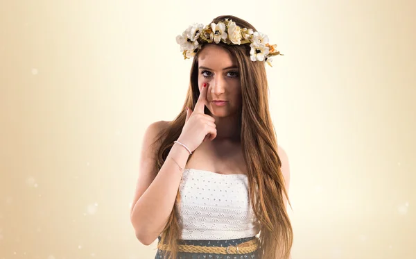 Chica con corona de flores mostrando algo —  Fotos de Stock