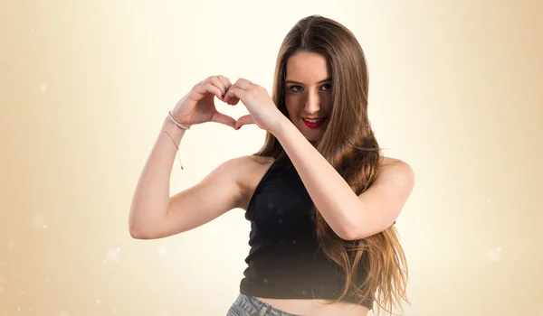 Ung flicka att göra ett hjärta med händerna — Stockfoto