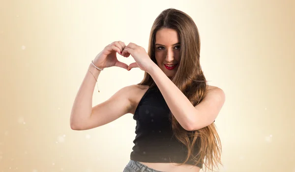 Chica joven haciendo un corazón con sus manos —  Fotos de Stock