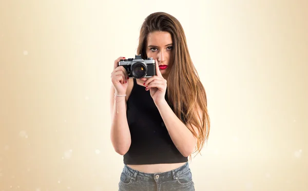 Chica joven sosteniendo una cámara — Foto de Stock