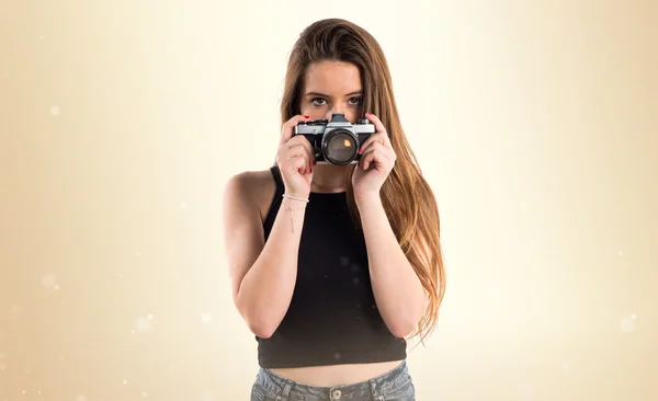 Chica joven sosteniendo una cámara — Foto de Stock