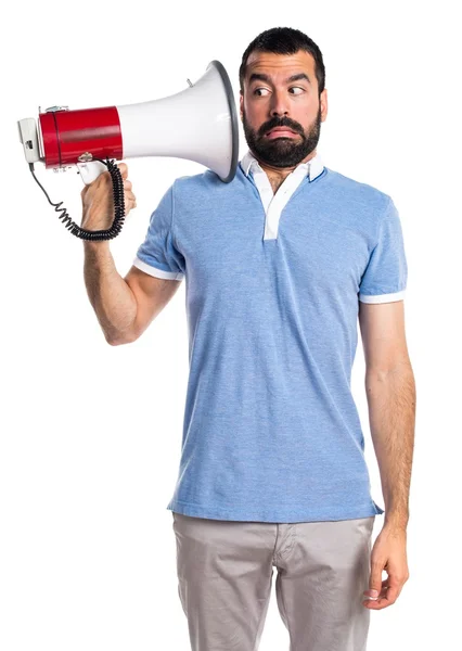 Человек в синей рубашке, кричащий на мегафон — стоковое фото