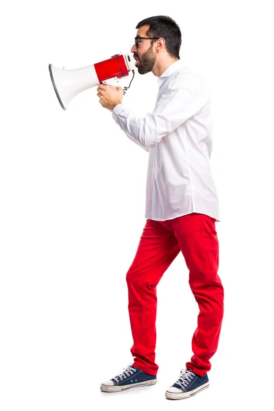 Bonito homem com óculos gritando por megafone — Fotografia de Stock