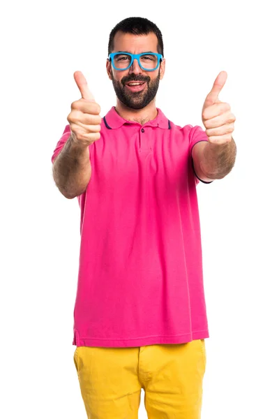 Man in kleurrijke kleding met duim omhoog — Stockfoto