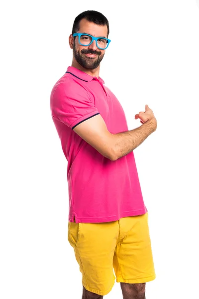 Uomo con vestiti colorati che puntano indietro — Foto Stock