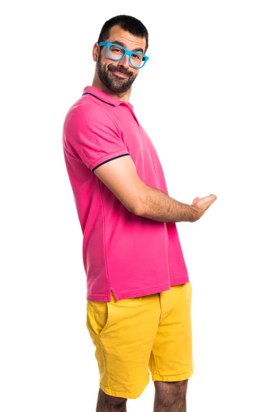 Άνθρωπος με πολύχρωμα ρούχα παρουσιάζει κάτι — Φωτογραφία Αρχείου