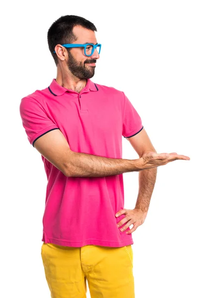 Muž s barevné oblečení prezentovat něco — Stock fotografie