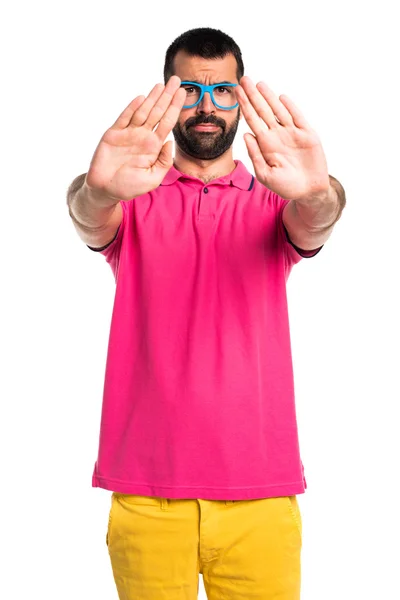 Mann mit bunten Klamotten macht Stoppschild — Stockfoto