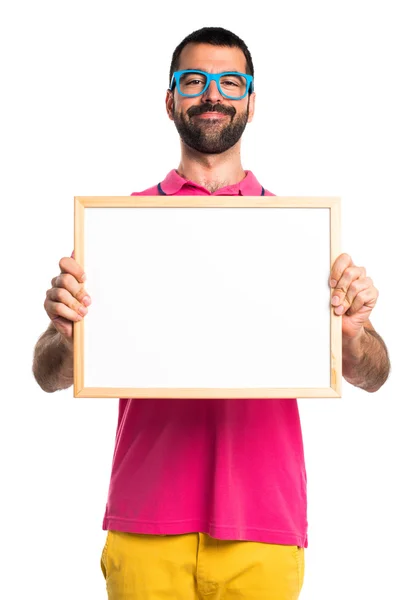 Człowiek z kolorowe ubrania przytrzymanie puste afisz — Zdjęcie stockowe