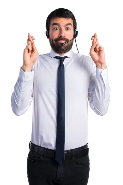 Jonge man met een headset met zijn vingers oversteken — Stockfoto