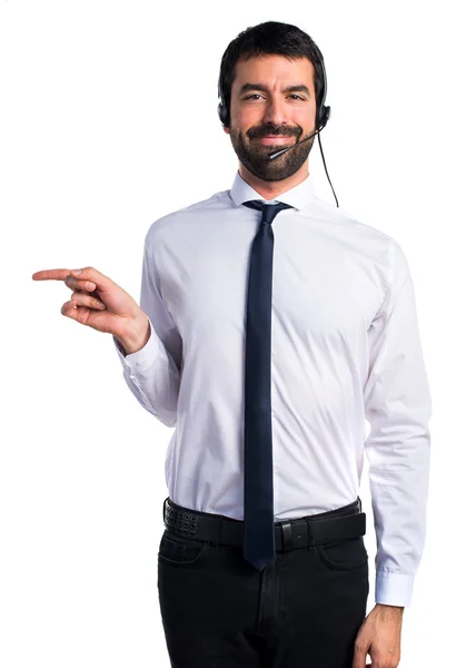 Young man with a headset pointing to the lateral — Stock Photo, Image