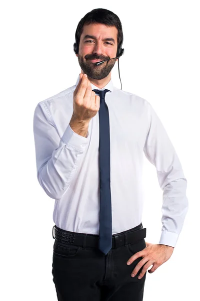 Joven con un auricular haciendo un gesto de dinero —  Fotos de Stock