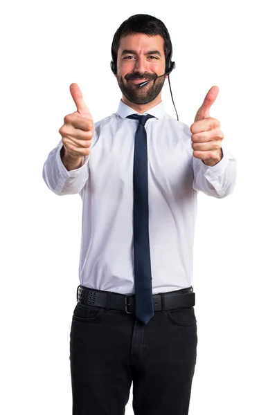 Jonge man met een headset met duim omhoog — Stockfoto