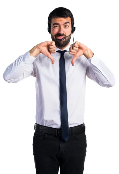 Young man with a headset doing bad signal — Stock Photo, Image