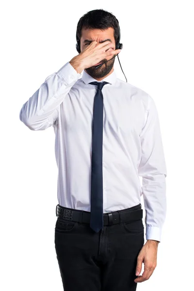 Young man with a headset doing smelling bad gesture — Stock Photo, Image