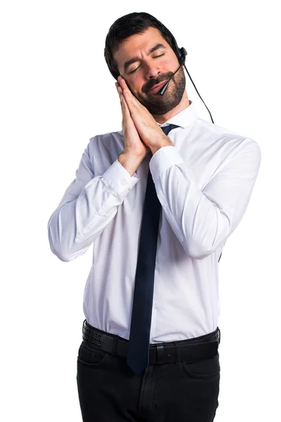 Young man with a headset doing sleep gesture — Stock Photo, Image
