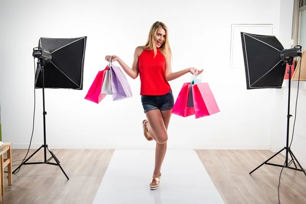 Woman with many shopping bags in studio — Stock Photo, Image