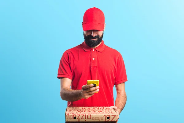 Entrega de pizza homem segurando um celular — Fotografia de Stock