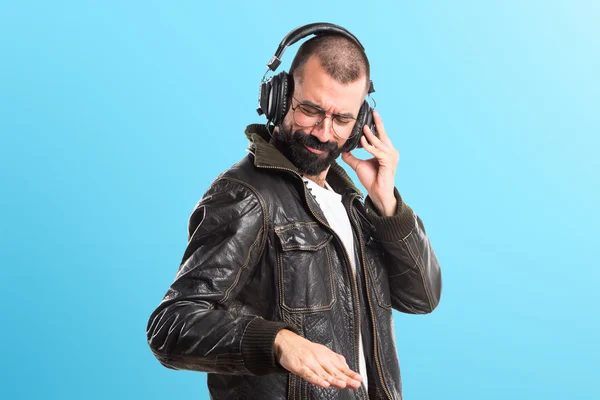 Hombre usando una chaqueta de cuero escuchando música —  Fotos de Stock