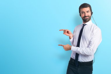 Lateral için işaret eden bir kulaklık ile genç adam