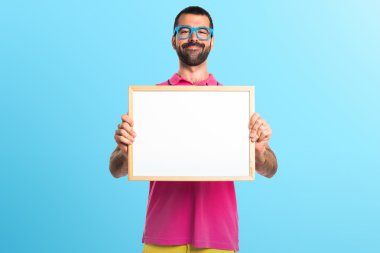 Renkli elbise boş bir afişini tutan adamla