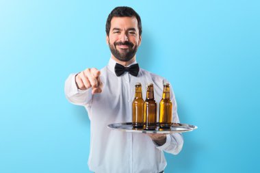 Garson bira şişeleri önüne işaret tepsi ile