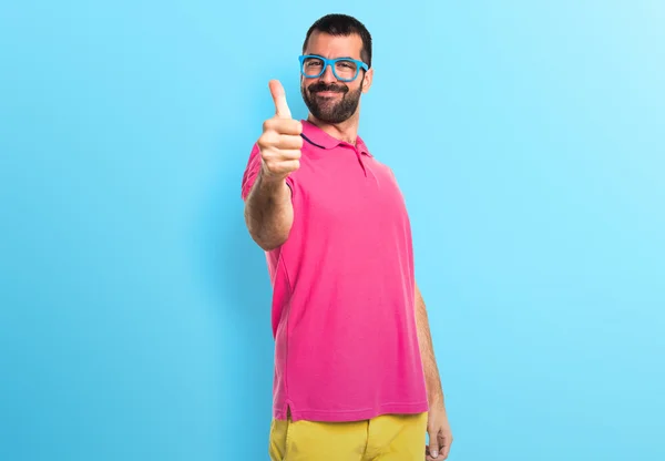 Mannen i färgglada kläder med tumme upp — Stockfoto