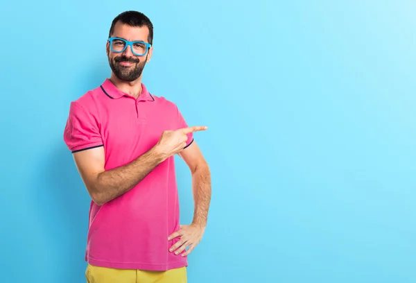 Mannen med färgglada kläder pekar på lateralen — Stockfoto