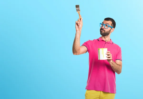 Mannen med färgglada kläder håller en paint pot — Stockfoto