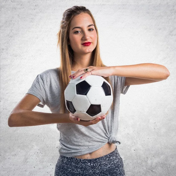 Mulher jogador segurando uma bola de futebol — Fotografia de Stock