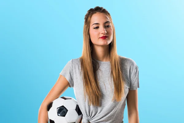 Mulher jogador segurando uma bola de futebol — Fotografia de Stock