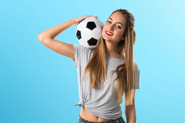 Женщина-игрок держит футбольный мяч — стоковое фото