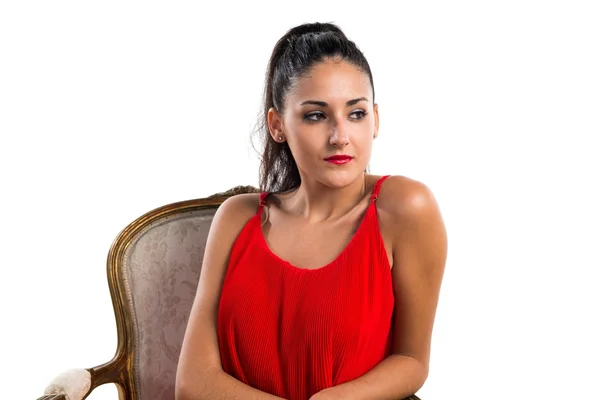 Pretty girl with red dress on vintage armchair — Stock Photo, Image