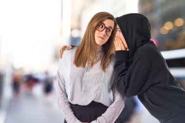 Ikiz kız fısıldamayı beyaz arka plan üzerinde  